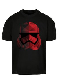 Černé bavlněné tričko s geometrickým designem helmy stormtroopera v červené barvě, s ostrými tvary a akcentem černého hledí.