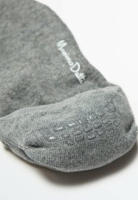 Gray sock made of textured fabric, featuring a reinforced toe area and branding. The design incorporates a subtle pattern along the edges.