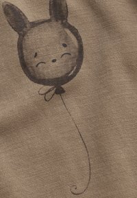 Brun tyg med en handritad ballong med ett kaninansikte, svarta konturer och mjuk textur. Ballongsnöret snirklar i änden.