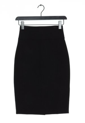 Czarna ołówkowa spódnica do kolan na czarnym wieszaku na białym tle.