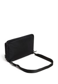 Bolsa acolchada negra con cierre de cremallera y una correa de tela ajustable. Presenta un diseño rectangular y elegante, con una textura suave.