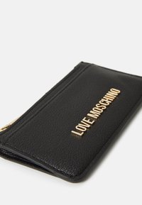 Black textured leather wallet with gold "LOVE MOSCHINO" lettering, featuring a zip closure and card slots. Compact rectangular design.