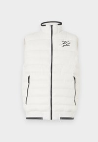 Balta pūkinė liemenė su aukštu apykakle, priekiniais užtrauktukais ir juodais akcentais. Apima dvi užtrauktukais uždarytus šoninius kišenes ir raštuotą apatinį kraštą su juostele.