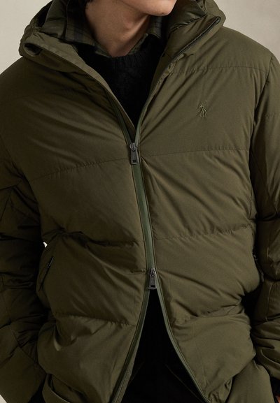 Casaco acolchoado verde com capuz, fecho de correr frontal e bolsos laterais. Apresenta um desenho acolchoado e logótipo bordado no peito.