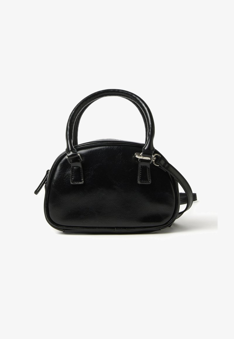 Sac à main noir en simili cuir lisse, présentant une forme incurvée, deux poignées supérieures, une bandoulière amovible et une fermeture zippée.