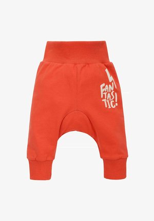 Helle orange Baumwoll-Jogginghosen mit lockerer Passform, geripptem Bund und Bündchen. Mit einem weißen grafischen Text auf dem linken Oberschenkel.