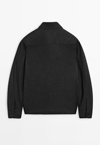 Giacca camicia a maniche lunghe grigio scuro con schiena dritta, polsini abbottonati e colletto classico, esposta in posizione piatta su uno sfondo bianco.