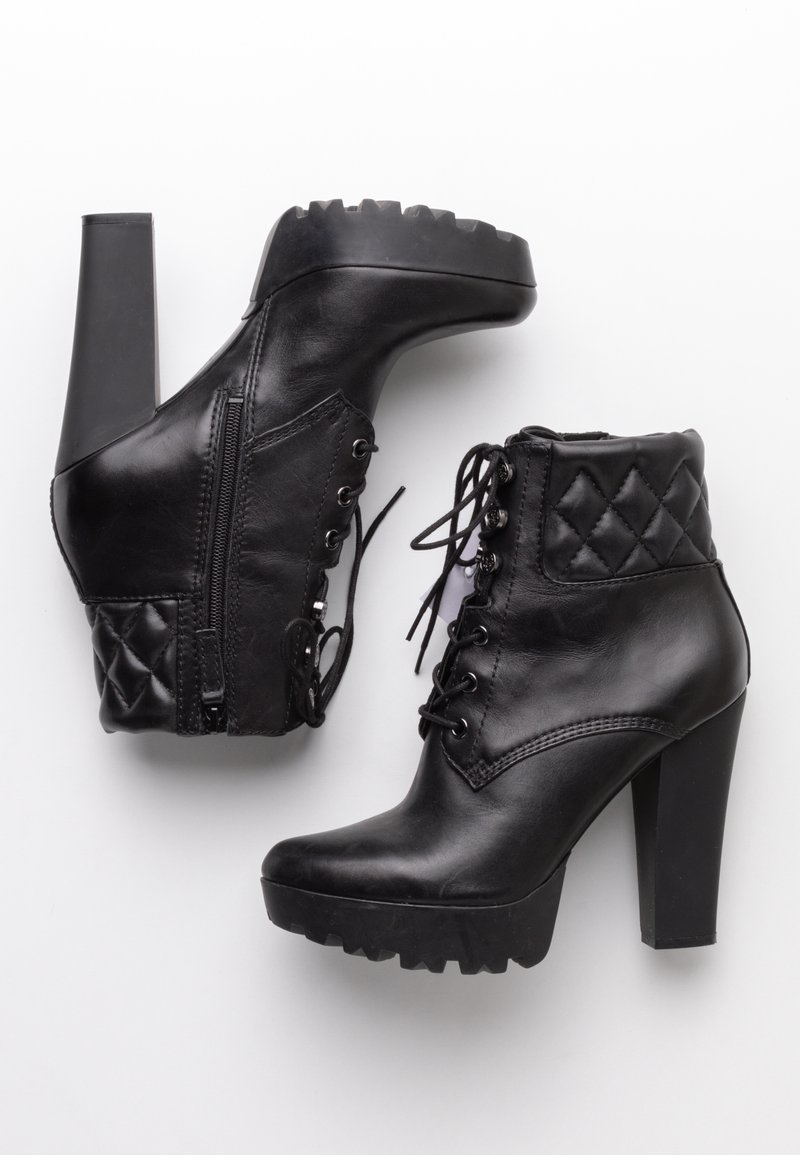 Paire de bottines à talons hauts en cuir noir avec lacets à l'avant, fermetures éclair latérales, cols matelassés et semelles épaisses à crampons.