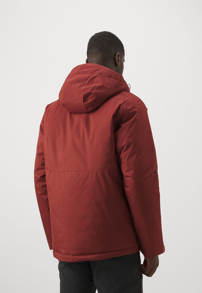 Chaqueta impermeable roja con capucha, presenta un corte recto, mangas largas y puños elásticos, mostrando una textura suave y un diseño minimalista.