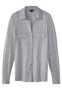 Graues Langarmshirt, weicher Stoff, Knopfleiste vorne, Kragen, zwei Brusttaschen und gerader Saum. Besitzt eine subtile Textur im gesamten Material.