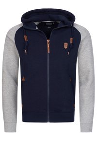 Navy and grey zip-up hoodie with a drawstring hood, contrasting sleeves, leather accents, and side pockets. Soft, textured fabric.