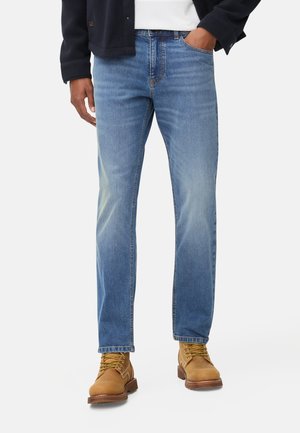 Lichtblauwe spijkerbroeken met rechte pijpen, voorzien van vervagingdetails en een klassiek vijf-pocket ontwerp, gecombineerd met tan kleurige boots.