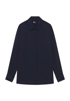 Marinebluse med en klassisk krave, lange ærmer, frontknapper og blonde-accenter ved ærmeenderne. Lavet af letvægtsstof.