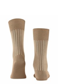 Beige sokker med lodrette hvide striber, ribbet tekstur foroven, sømløs tå og forstærket hæl for holdbarhed.