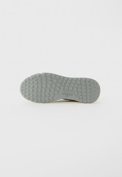 Gray shoe sole with round nubs evenly spaced, featuring "Hogan" branding embossed near the arch area on a plain background.