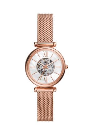 Orologio da polso in oro rosa con cinturino a maglia, quadrante bianco, numeri romani e movimento meccanico visibile al centro.