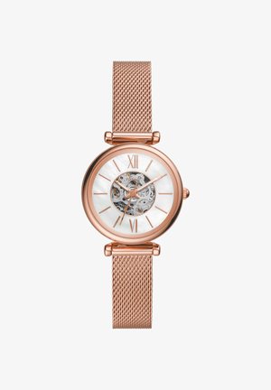 Montre-bracelet en or rose avec bracelet en maille, cadran blanc, chiffres romains et mouvement mécanique visible au centre.