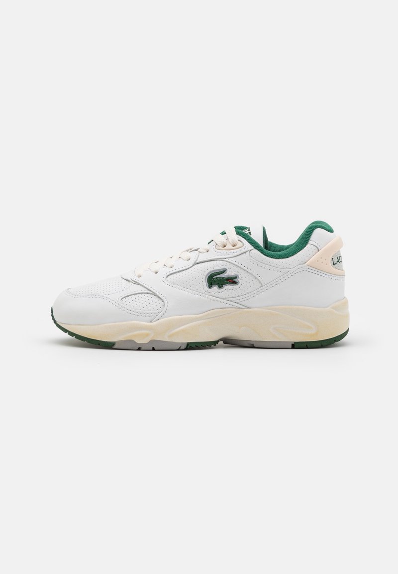 White athletic shoe with green accents, textured leather upper, round toe, lace closure, and a cushioned sole with light grey and green detailing.