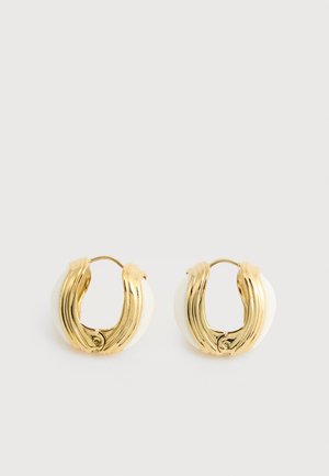 Gold-toned hoop earrings with curved, ribbed metal design and white resin backing, shown side by side on a neutral background.