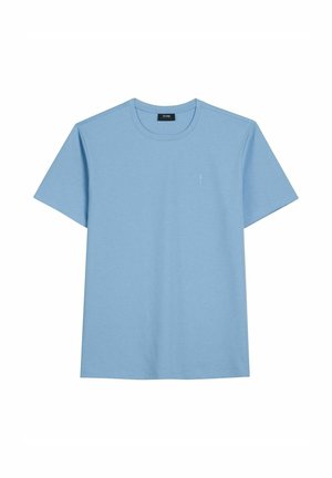 Jasnoniebieski, krótkim rękawem, z okrągłym dekoltem T-shirt z małym, subtelnym logo na lewej piersi, na białym tle.