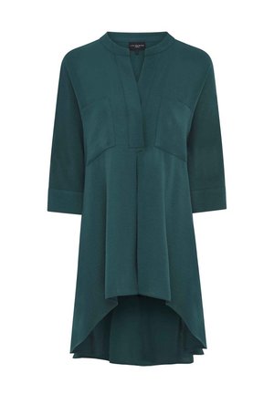 Tumma tealinsininen tunikamekko, jossa on korkeampi etuhelma, 3/4-hihat, halkio kaula-aukossa ja kaksi rintataskua.