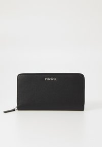 Zwarte leren portemonnee met een gestructureerd oppervlak, ritssluiting en zilveren "HUGO" logo aan de voorkant. Compacts rechthoekig formaat.