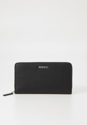 Black leather wallet featuring a textured finish, zippered closure, and silver "HUGO" logo at the front. Compact rectangular shape.