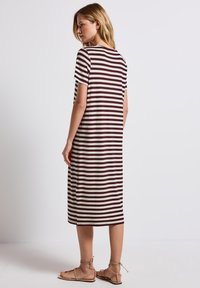 Robe rayée en rouge foncé et crème, à manches courtes, longueur genoux, en tissu doux, avec une coupe ample et décontractée.