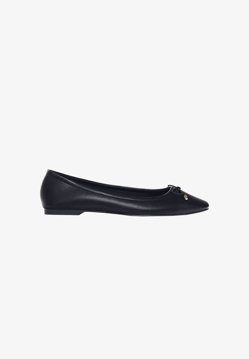 Schwarze Ballerinas aus glattem Leder, mit spitzem Zehenbereich, dünnem Absatz und einer dekorativen Schleife mit einem goldenen Akzent an der Vorderseite.
