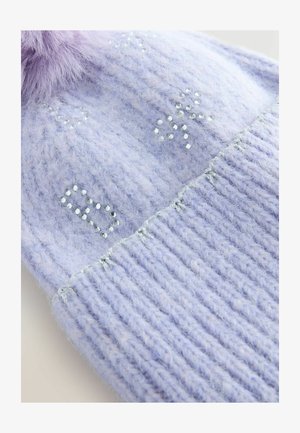 Gebreide lila beanie met een geribbelde textuur, versierd met zilverkleurige kralen die patronen vormen en een zachte paarse nep-vossenbont pompon bovenop.