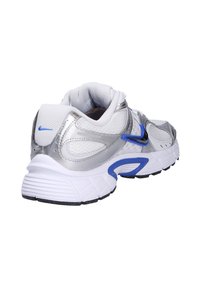 Scarpe da ginnastica argento e bianche con tessuto in rete, collo imbottito, dettagli blue e suola bianca spessa con particolari di trazione nera.