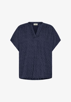 Blouse à manches courtes bleu marine à pois blancs, encolure en V avec un léger volant et coupe ample.