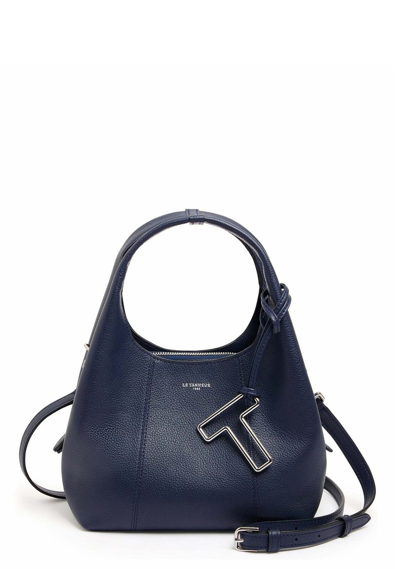 Borsa in pelle blu navy con silhouette arrotondata, superficie texturizzata, hardware in tonalità argento e un prominente accento 'T' sul davanti. Manico regolabile.