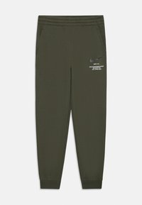Nike treningo kelnės tamsiai alyvuogių spalvos, pagamintos iš sklandžios medžiagos. Turi šonines kišenes, elastingą juosmenį ir mažą baltą logotipo spaudą ant šlaunies.