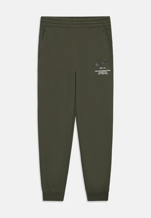 Nike joggebukser i mørk oliven grønn, laget av glatt stoff. Har sidelommer, en elastisk midjebånd og liten hvit logo trykt på låret.
