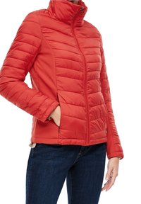 Veste doudoune rouge avec un motif matelassé, col haut et fermeture éclair à l'avant. Équipée de poches latérales et d'une coupe ajustée. Texture douce.