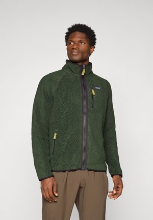 Veste en polaire de couleur vert foncé avec une finition texturée, col haut, fermeture éclair sur le devant et deux poches latérales zippées avec des tirettes de zip contrastantes.