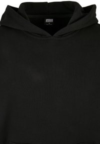 Sudadera con capucha negra hecha de una tela suave. Presenta un bolsillo tipo canguro y un diseño sencillo sin patrones ni elementos visibles.