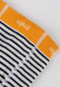 Gestreifte Socken mit marineblauen und cremefarbenen Streifen, einem orangefarbenen Bund und weißer Markenkennzeichnung. Weicher Stoff, enganliegende Passform und saubere Nähte.