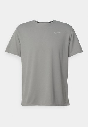 Γκρίζο μπλουζάκι Nike με κοντά μανίκια, στρογγυλή λαιμόκοψη και μικρό ασημί λογότυπο στην αριστερή πλευρά του στήθους. Κατασκευασμένο από μαλακό, ελαφρύ ύφασμα.
