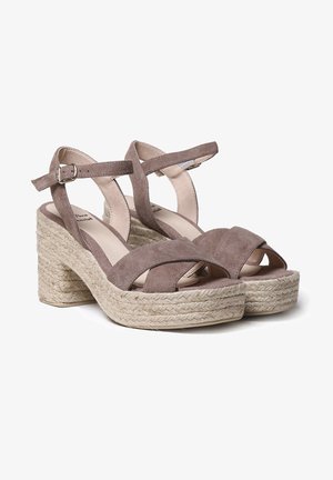Sandales compensées en daim marron avec une plateforme en corde style espadrille, des brides croisées et une fermeture à boucle à la cheville.
