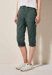 Dark green, cropped cargo pants with rolled cuffs, two front pockets, and a flat front, made from lightweight fabric.