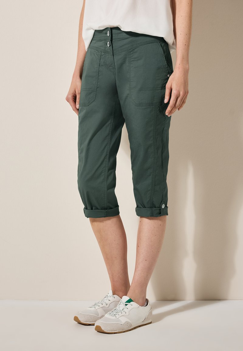 Dark green, cropped cargo pants with rolled cuffs, two front pockets, and a flat front, made from lightweight fabric.