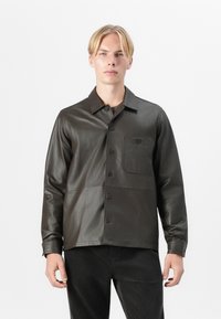 Dunkelgrüne Lederhemdjacke mit Knopfleiste, spitzem Kragen, einer Brusttasche und glatter Textur. Geeignet für legere Anlässe.