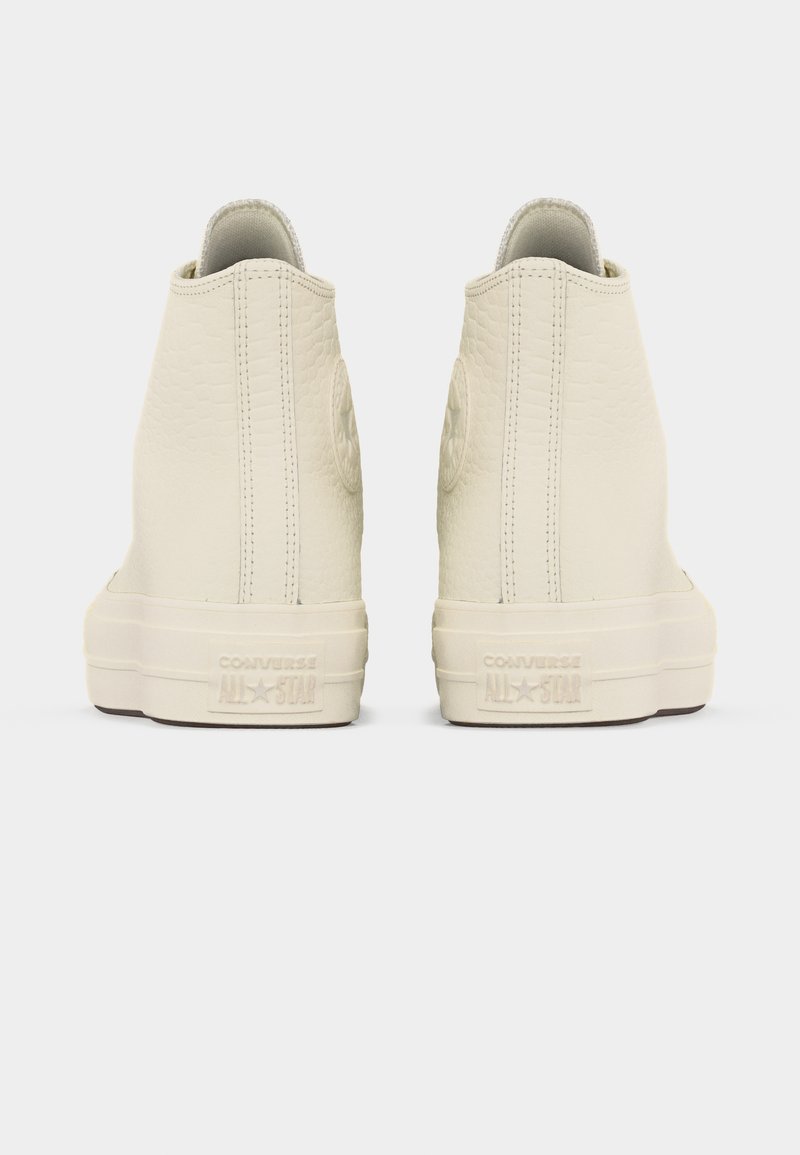 Coppia di sneakers Converse All Star alte bianco sporco viste dal retro, tomaia testurizzata con cucitura verticale e suola in gomma.