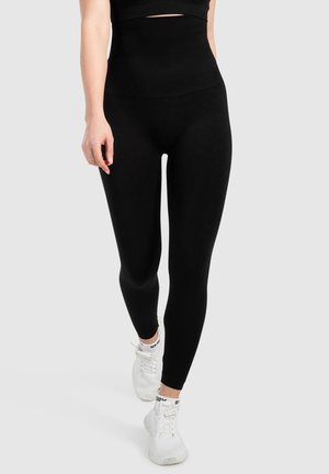 Leggings negros de tiro alto hechos de material elástico, que presentan una textura suave y un diseño ajustado que se adapta a las piernas.