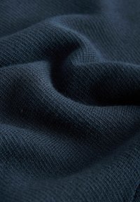 Dark blue knit fabric with a soft texture, featuring a fine, even weave and some subtle variations in shading.