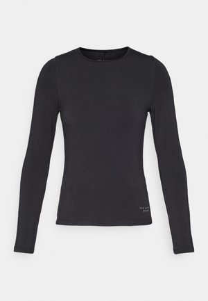 Zwarte langemouwen top van zachte stof met een ronde halslijn en minimale branding aan de onderkant. Gladde textuur en slim-fit ontwerp.
