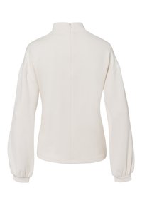 Licht crèmekleurige pullover met een hoge kraag, lange pofmouwen en een ritssluiting midden aan de achterkant. Zacht materiaal met een gladde textuur en minimale naden.
