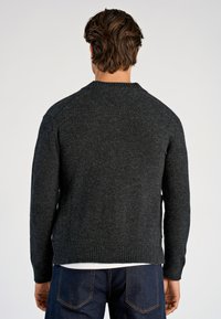 Tummanharmaa neulepaita pyöreällä pääntiellä ja resorireunuksilla hihoissa. Pintakuviointi on pehmeä ja hieman joustava, sopiva arkikäyttöön.